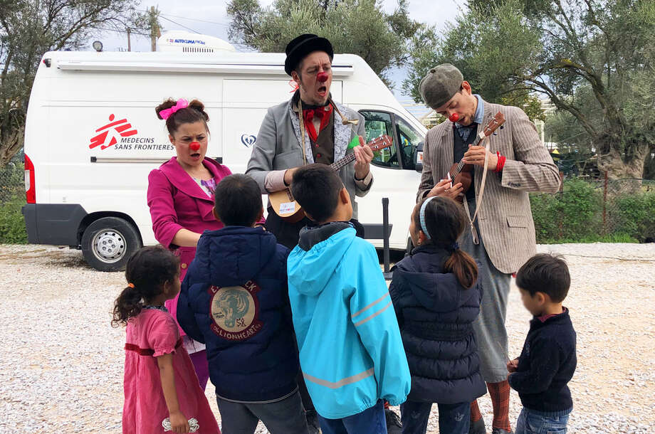 Group of healthcare clowns play with refugee kids