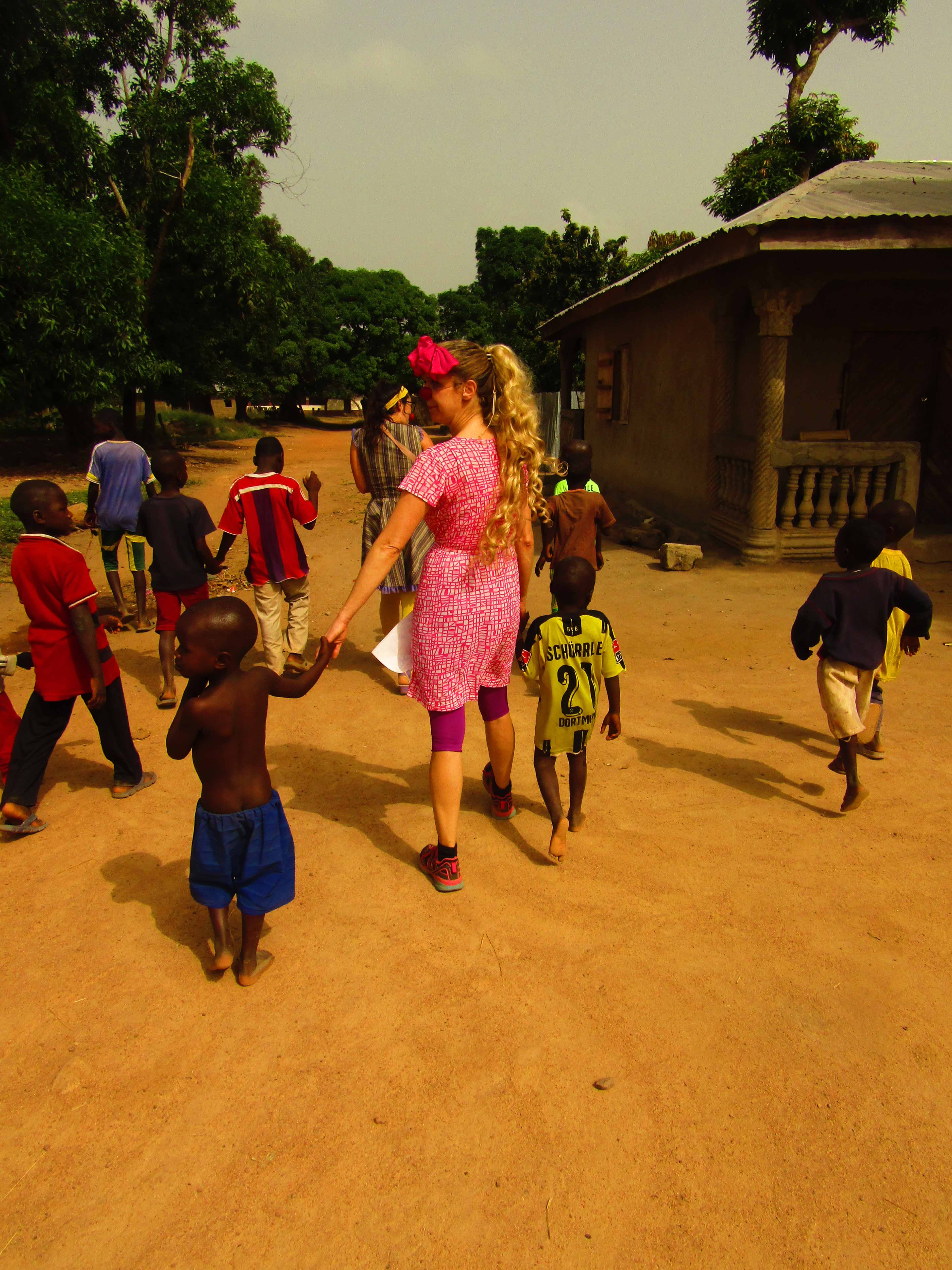 clown doctor Florentine Schara surrounded by children from Sierra Leone